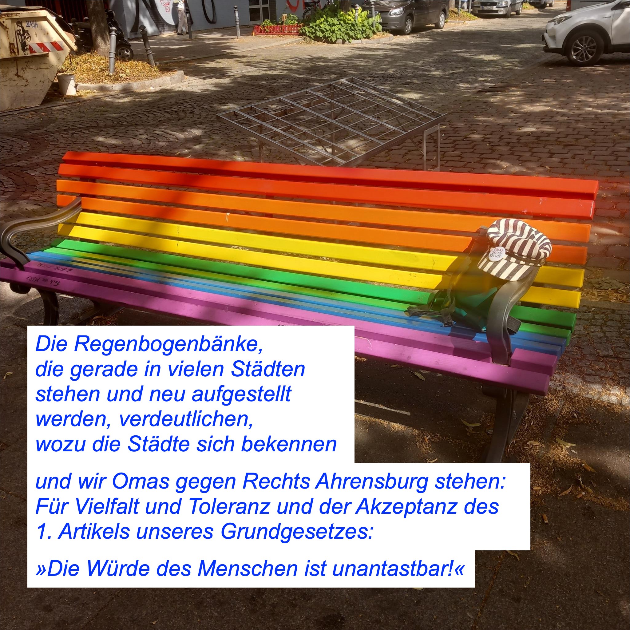 Bank in Regenbogenfarben mit Text: Die Regenbogenbänke, 
die gerade in vielen Städten stehen und neu aufgestellt werden, verdeutlichen, 
wozu die Städte sich bekennen und wir Omas gegen Rechts Ahrensburg stehen: 
Für Vielfalt und Toleranz und der Akzeptanz des 1. Artikels unseres Grundgesetzes:
»Die Würde des Menschen ist unantastbar!«